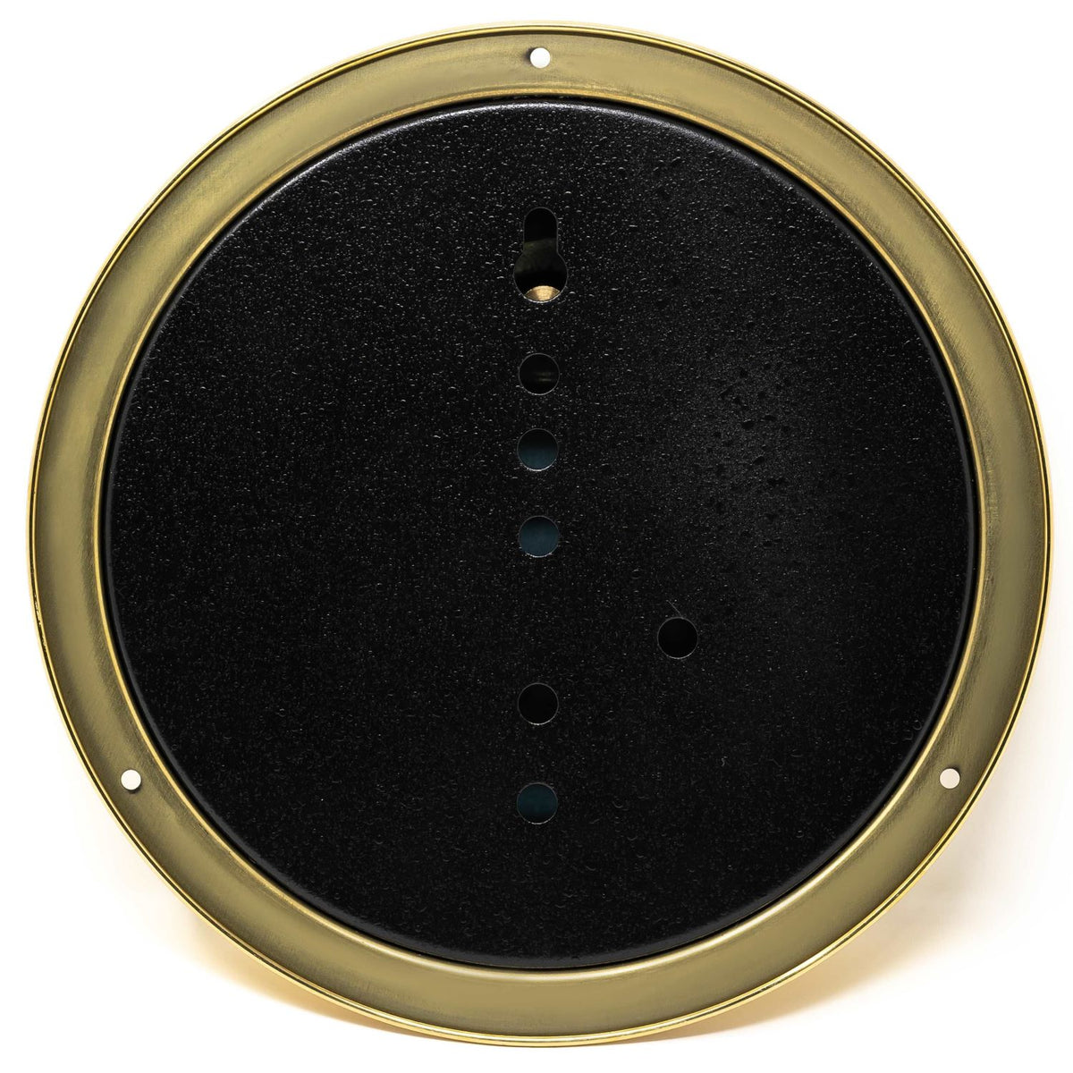 Back of a round brass barometer or clock wall mounting plate with drilled holes