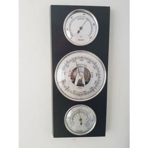 Wall-mounted weather station with barometer, hygrometer, and thermometer on black panel