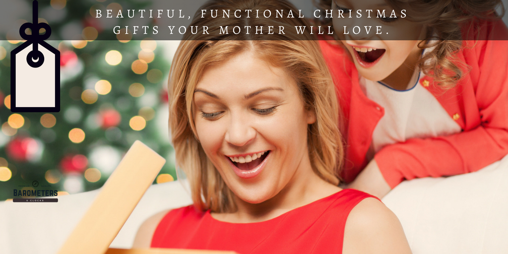 Smiling woman opening Christmas gift box with child, festive holiday background.