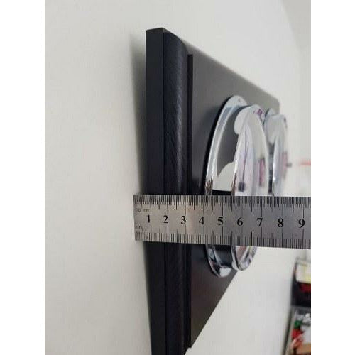 Side view of wall-mounted barometer and clock panel with ruler measuring thickness